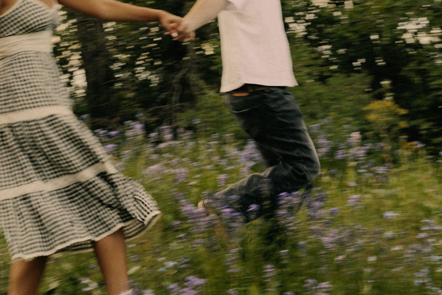 Motion blur of couple dancing in field of purple flowers.