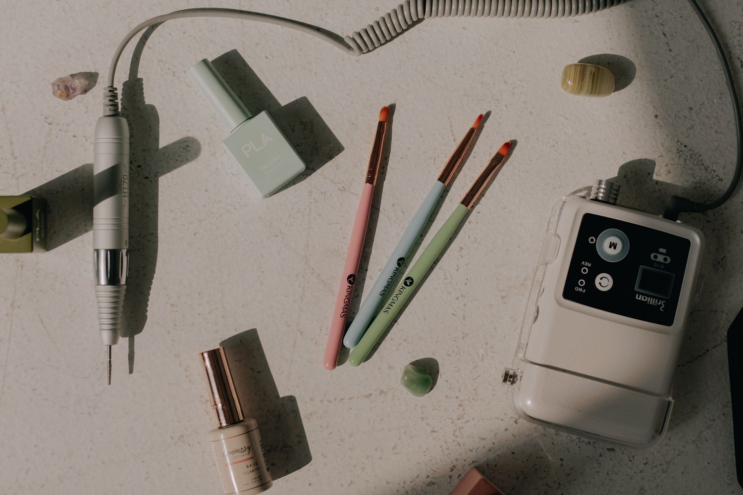 Flat lay of creative supplies and tools on a light gray surface.