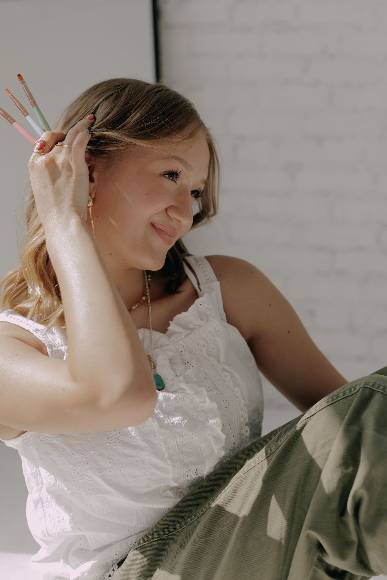 Artistic portrait series showing relaxed poses in white lace and olive green clothing.