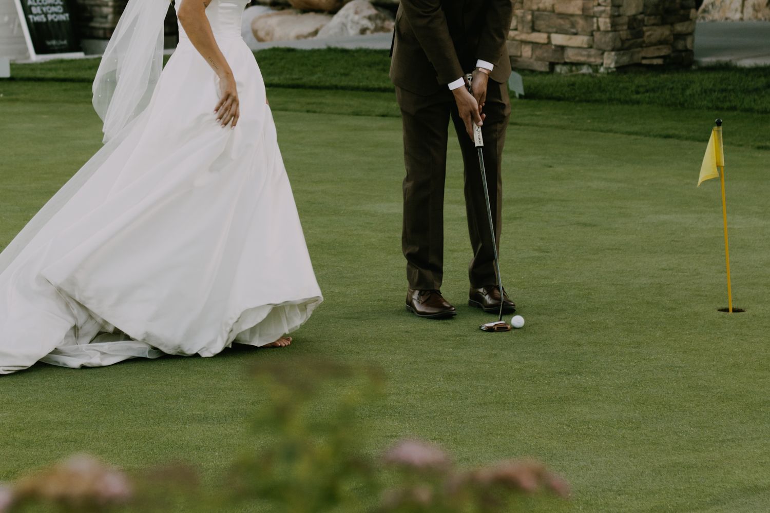 Bride and groom share romantic moment on golf course during wedding celebration.