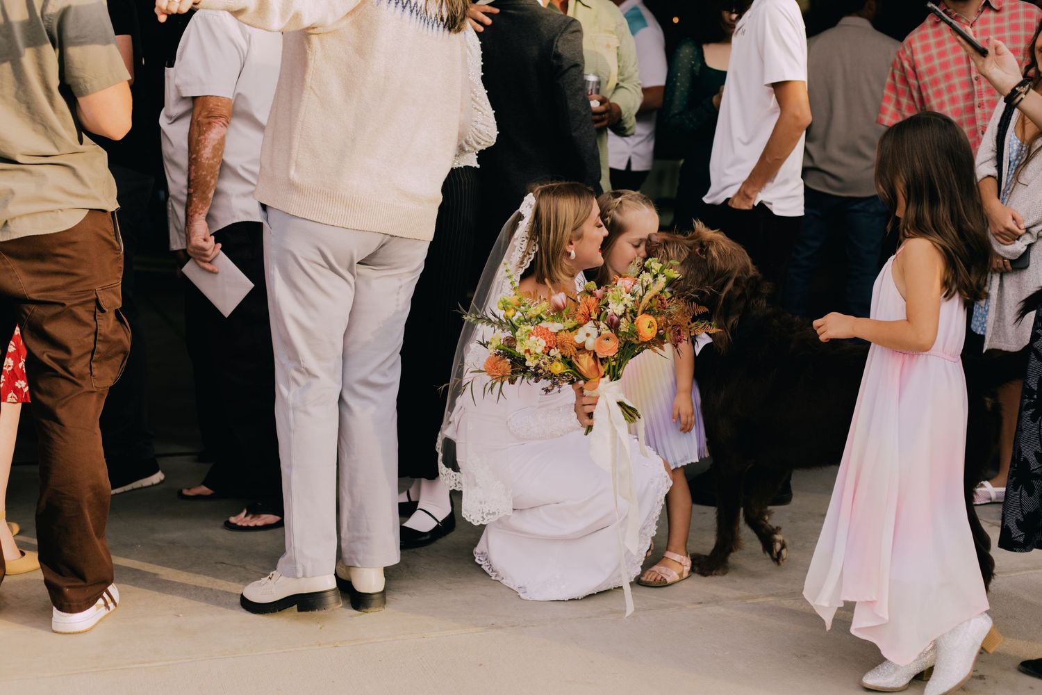 Wedding reception scene with guests in white and casual attire mingling.