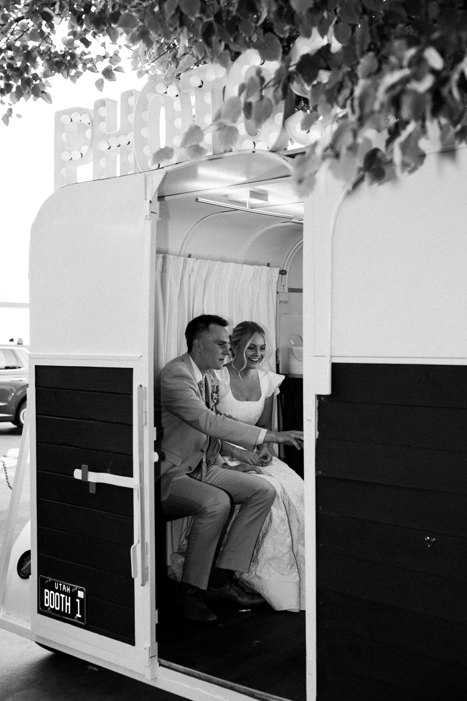 Black and white photo booth strip showing a couple's playful interactions.