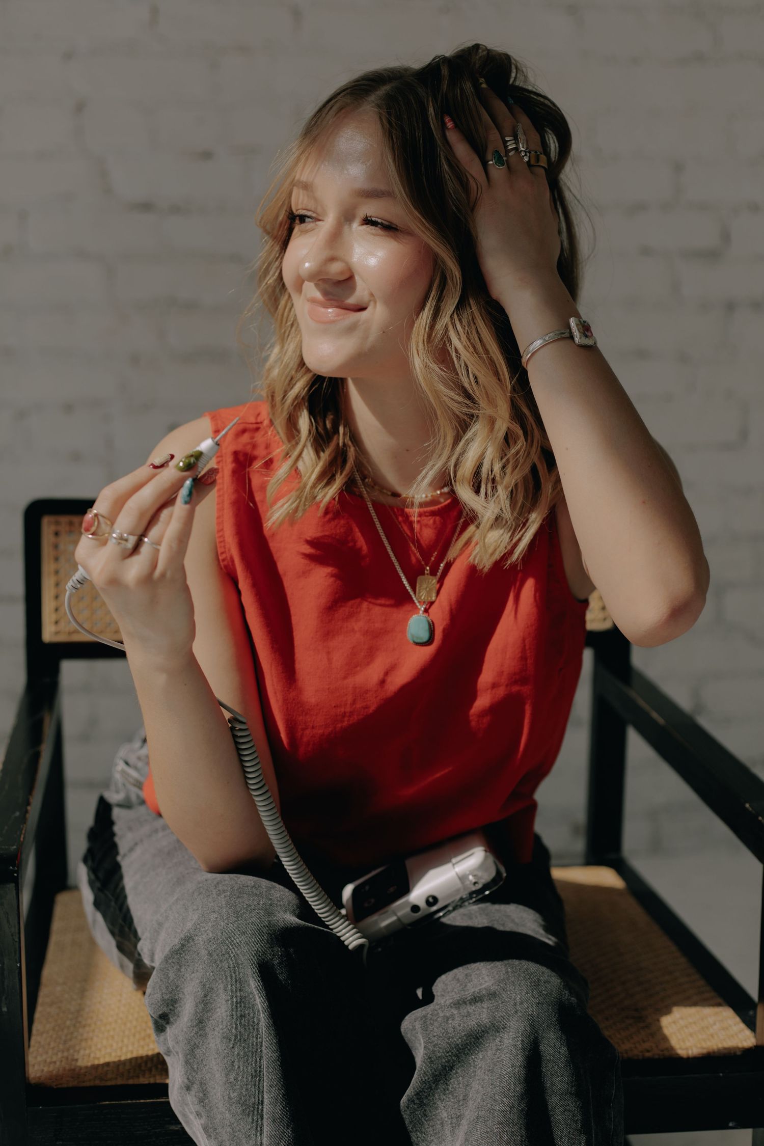 Candid shot showing joyful expression while seated in wooden chair.