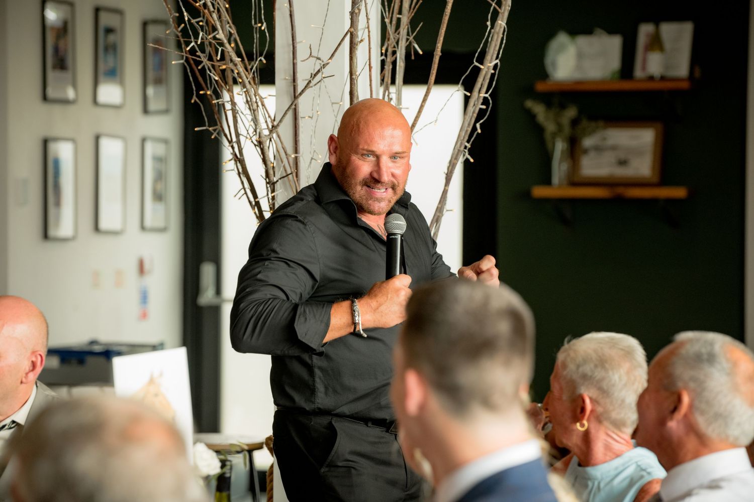 Singing waiter in black shirt entertaining guests at wedding reception.