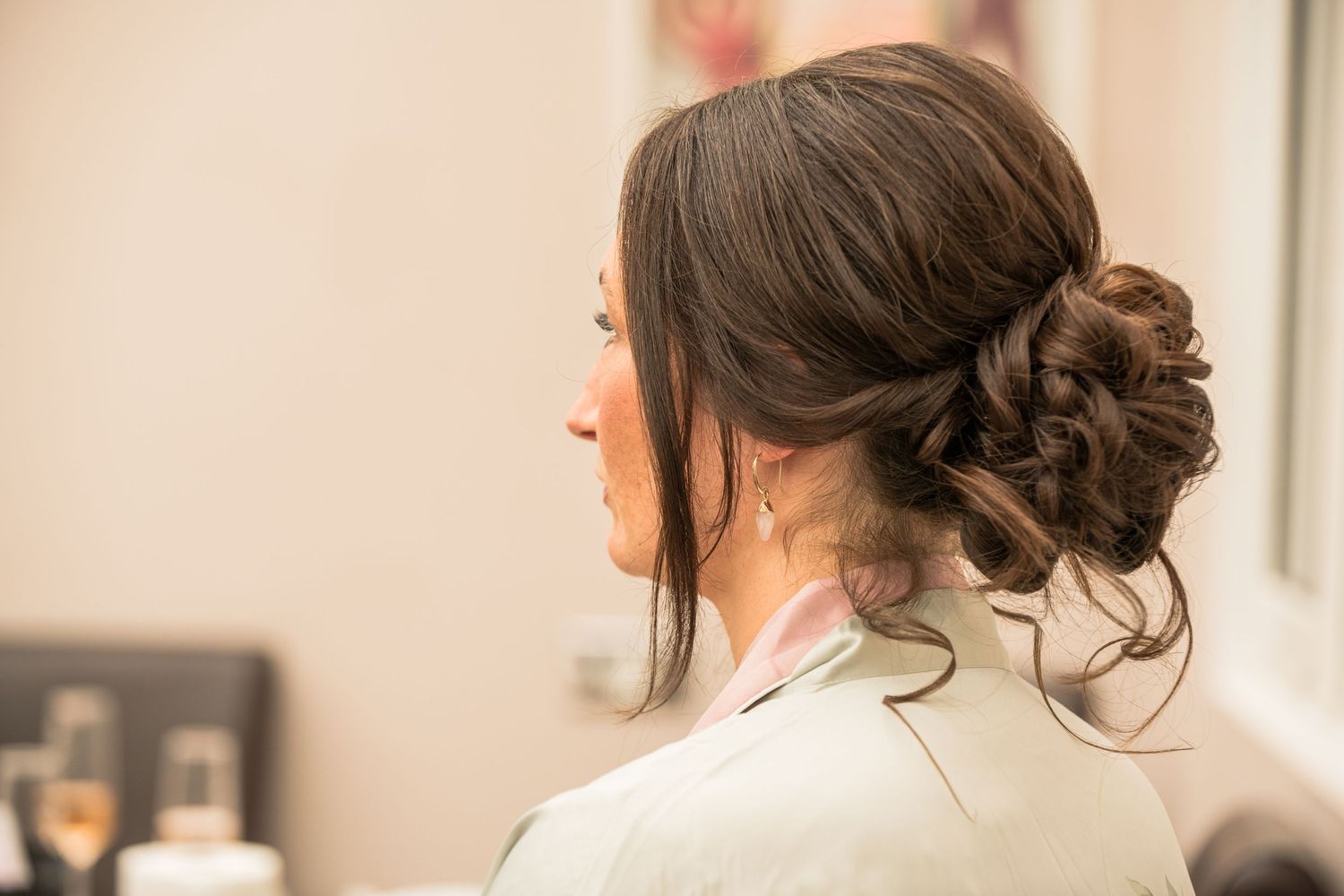Elegant bridal updo hairstyle with twisted bun photographed from behind in soft natural light.