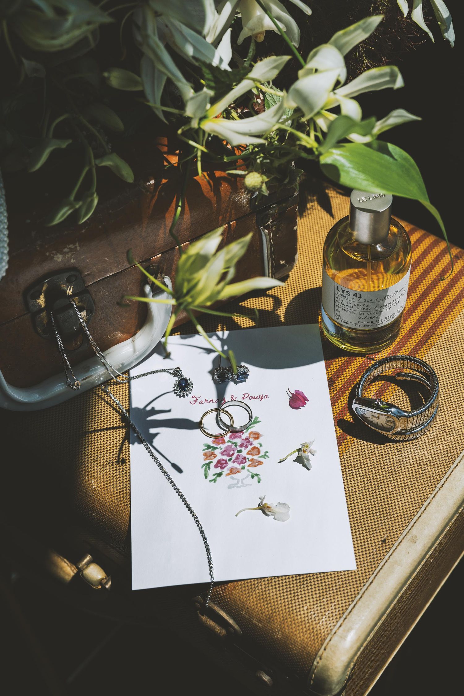 Artistic sketches of flowers and bees on white paper with plant decorations in moody lighting.