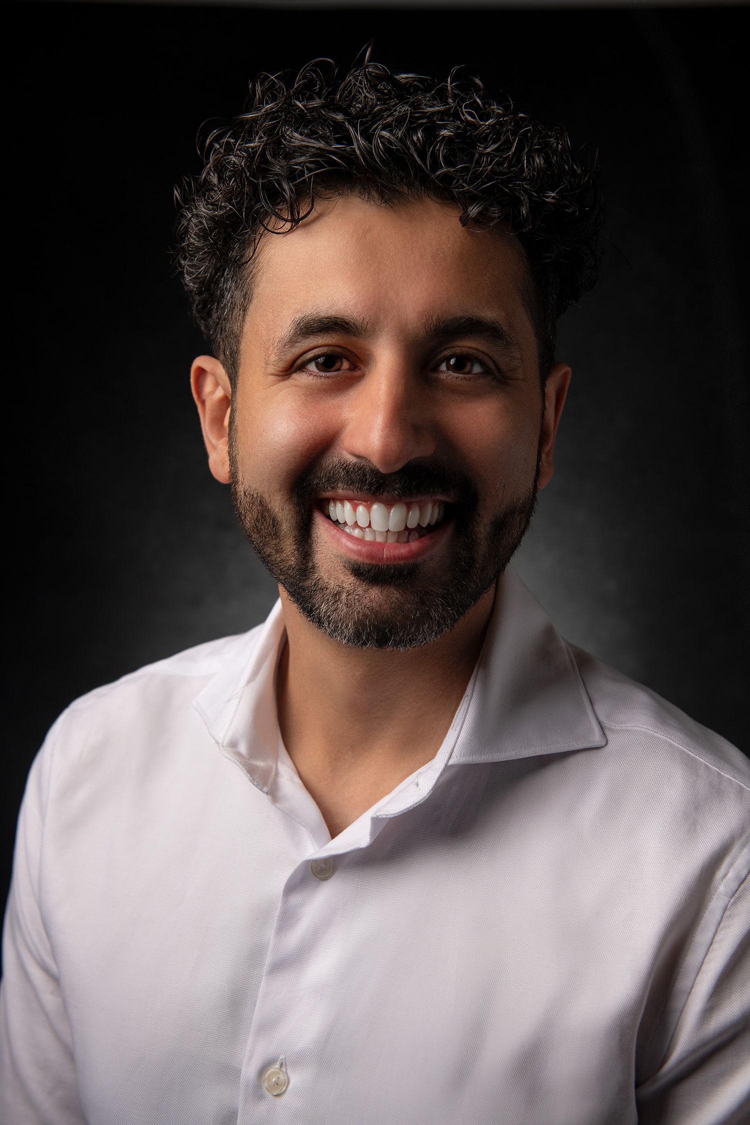 Candid series of headshot expressions showing warm smile in white shirt against dark backdrop taken in Westwood Los Angeles studio.