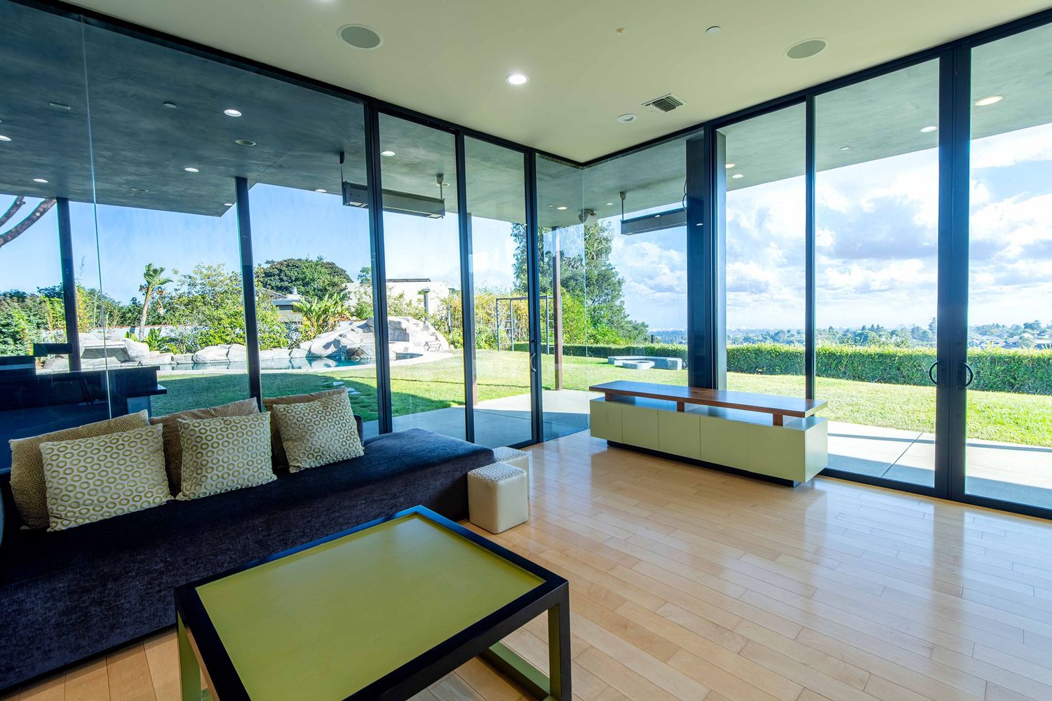 Modern office space with black stone accent wall features floor-to-ceiling windows and natural wood flooring.