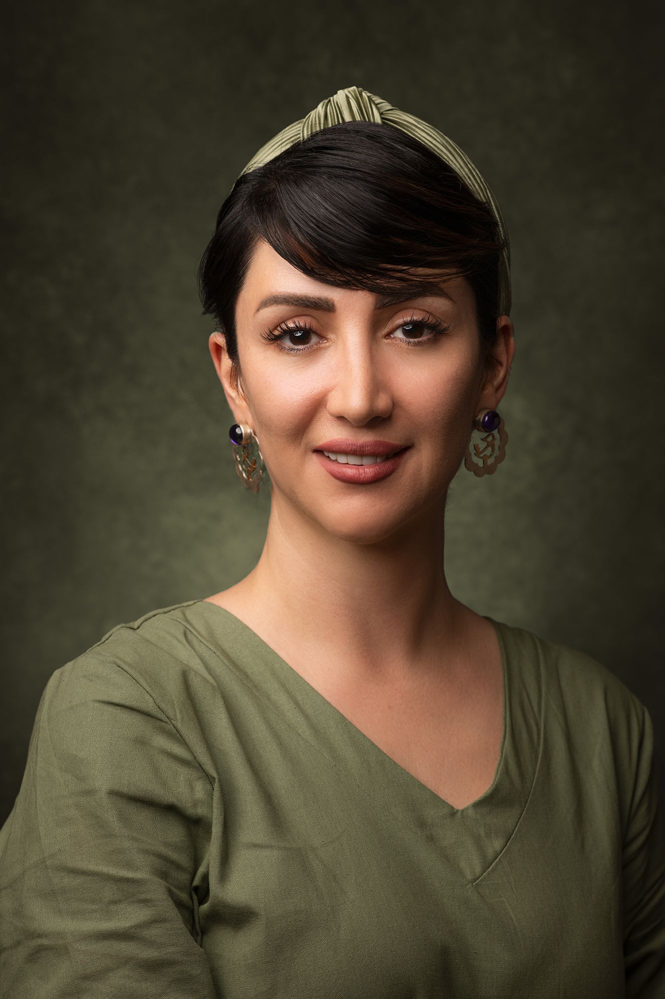 Portrait and headshot sequence of person wearing olive green top and cap against dark background taken in west Los Angeles.