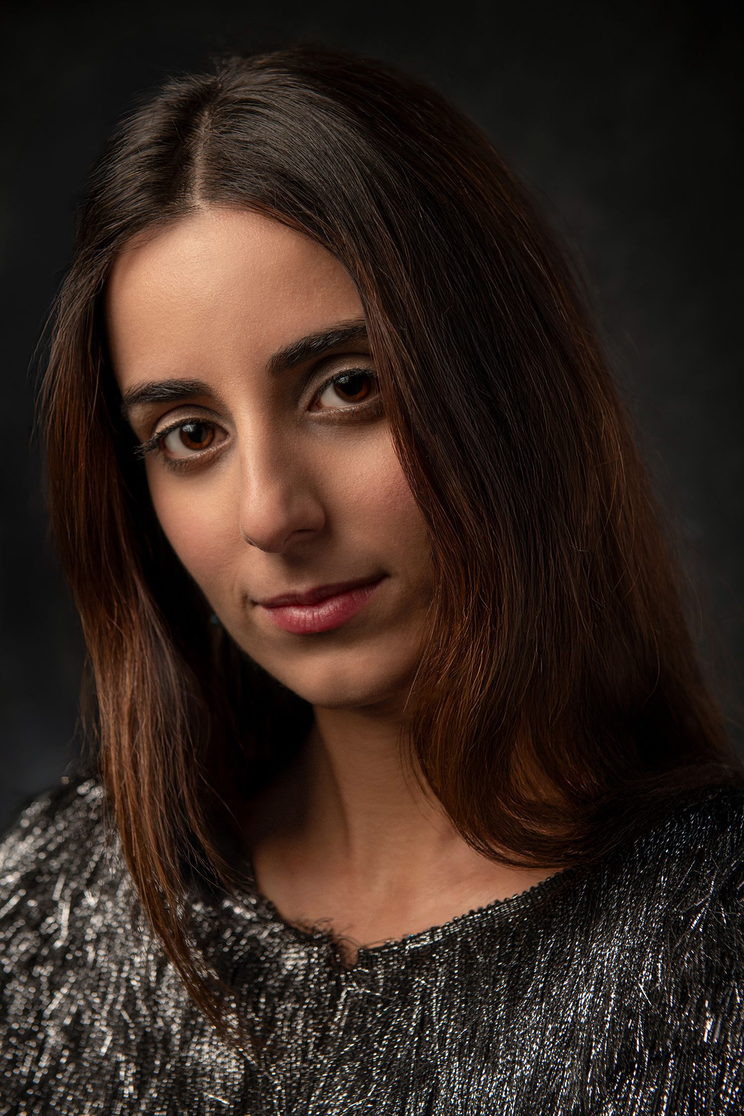Stylish portrait series with metallic sweater and dramatic side lighting taken in Westwood Los Angeles studio.