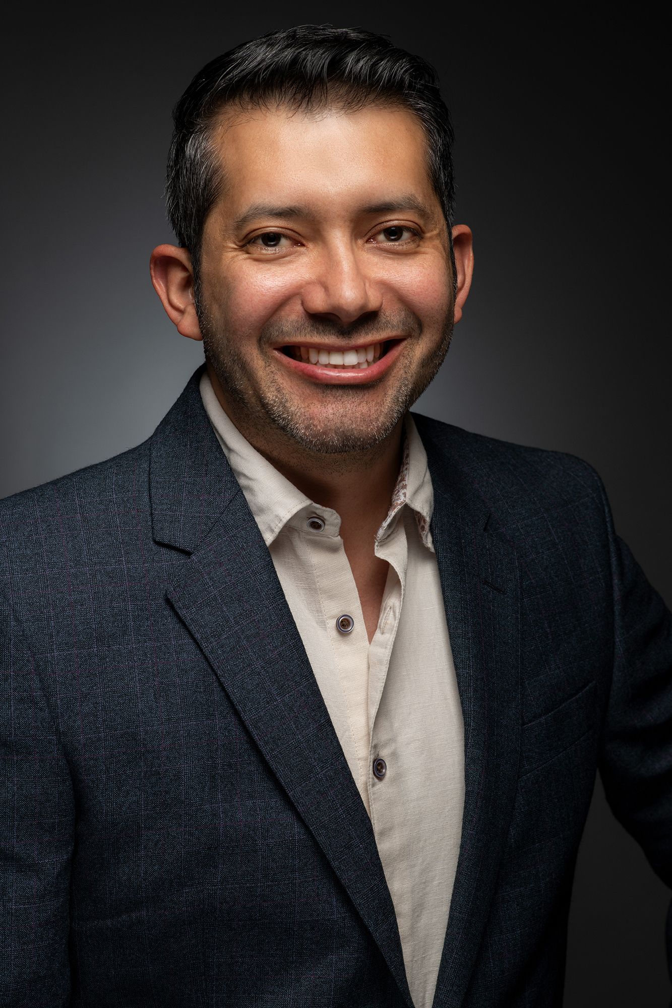 Professional commercial headshot and portrait of CEO in navy suit and light shirt against dramatic lighting taken in west Los Angeles.