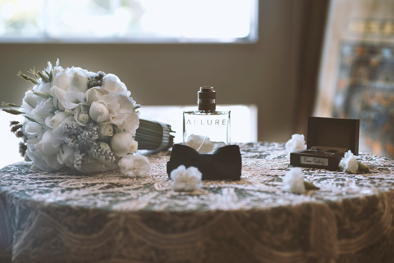 White floral wedding centerpieces arranged on rustic wooden tables create an elegant reception setting.