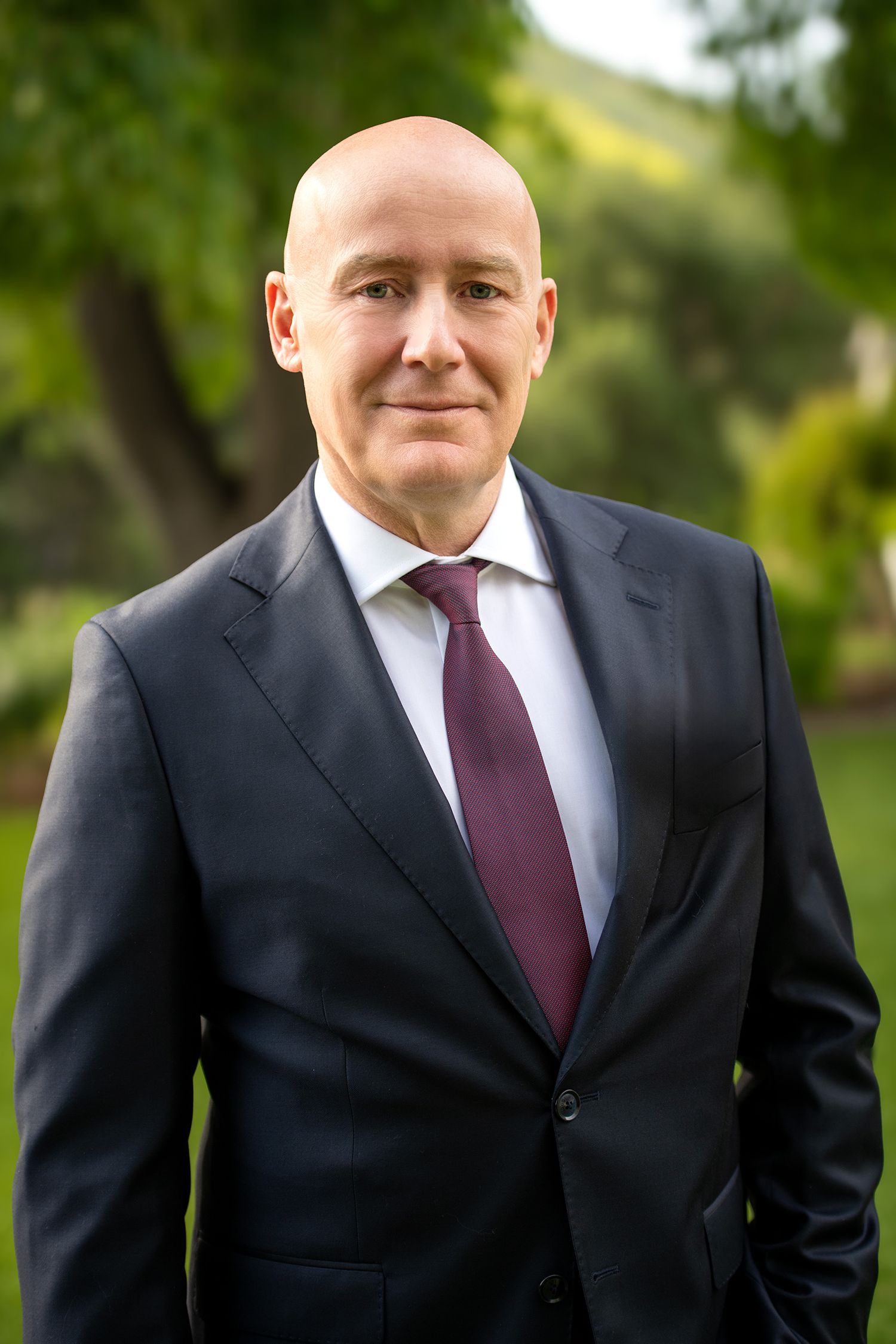 Professional headshot of businessman in navy suit with burgundy tie outdoors taken in Westwood Los Angeles studio
