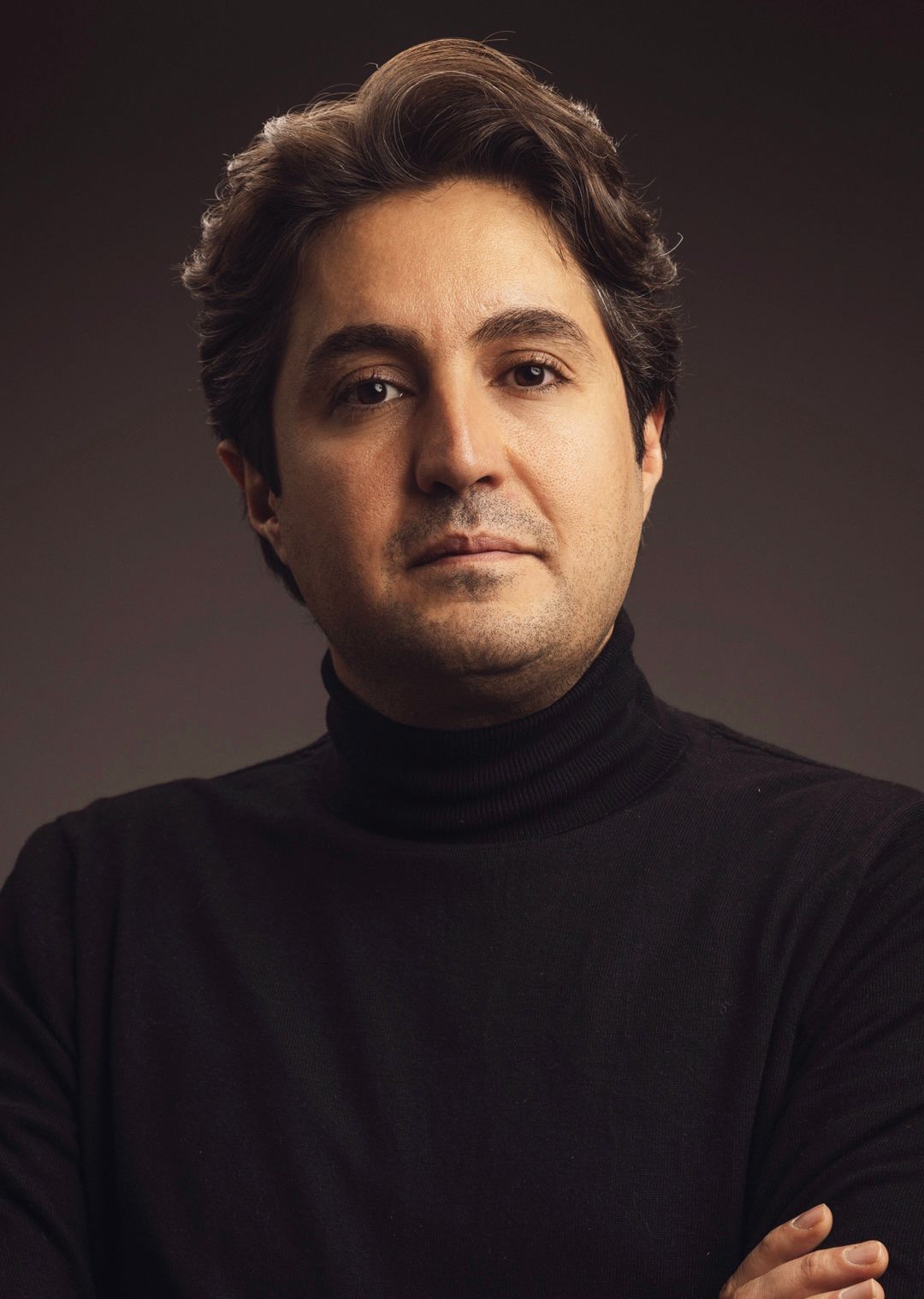 Portrait and headshot of Saeid Kaveh in black turtleneck sweater against dark studio background taken in West Los Angeles.