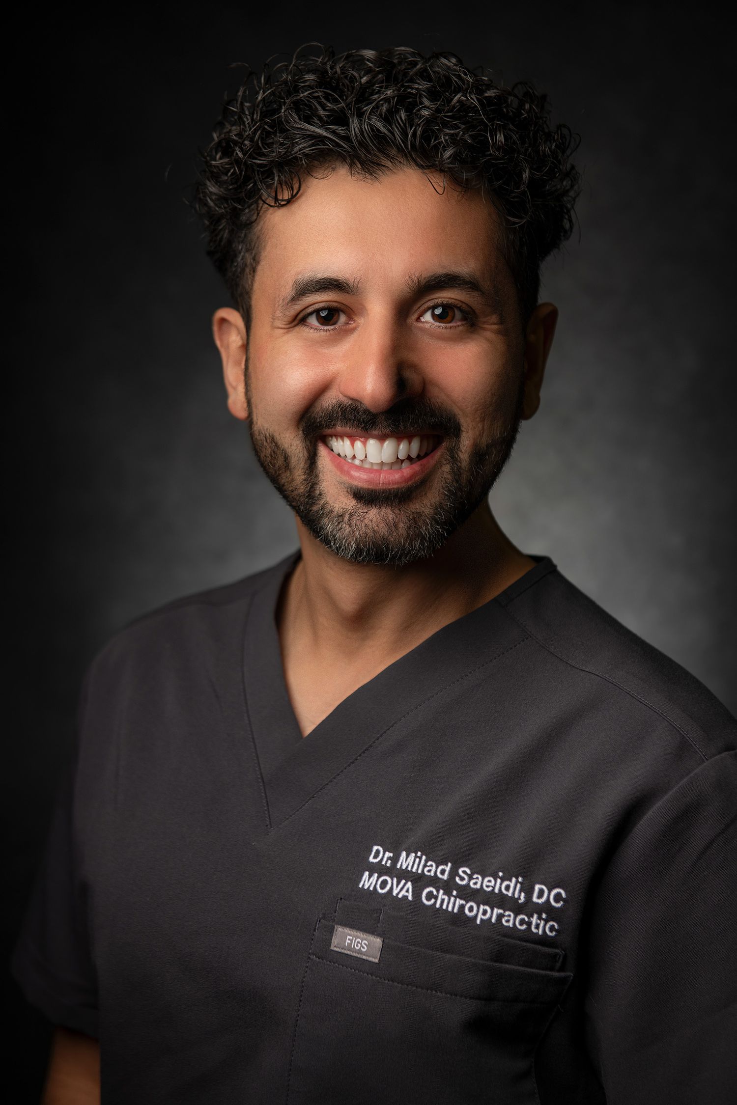 Medical professional in grey scrubs smiling warmly in studio portrait. headshot taken in Westwood Los Angeles