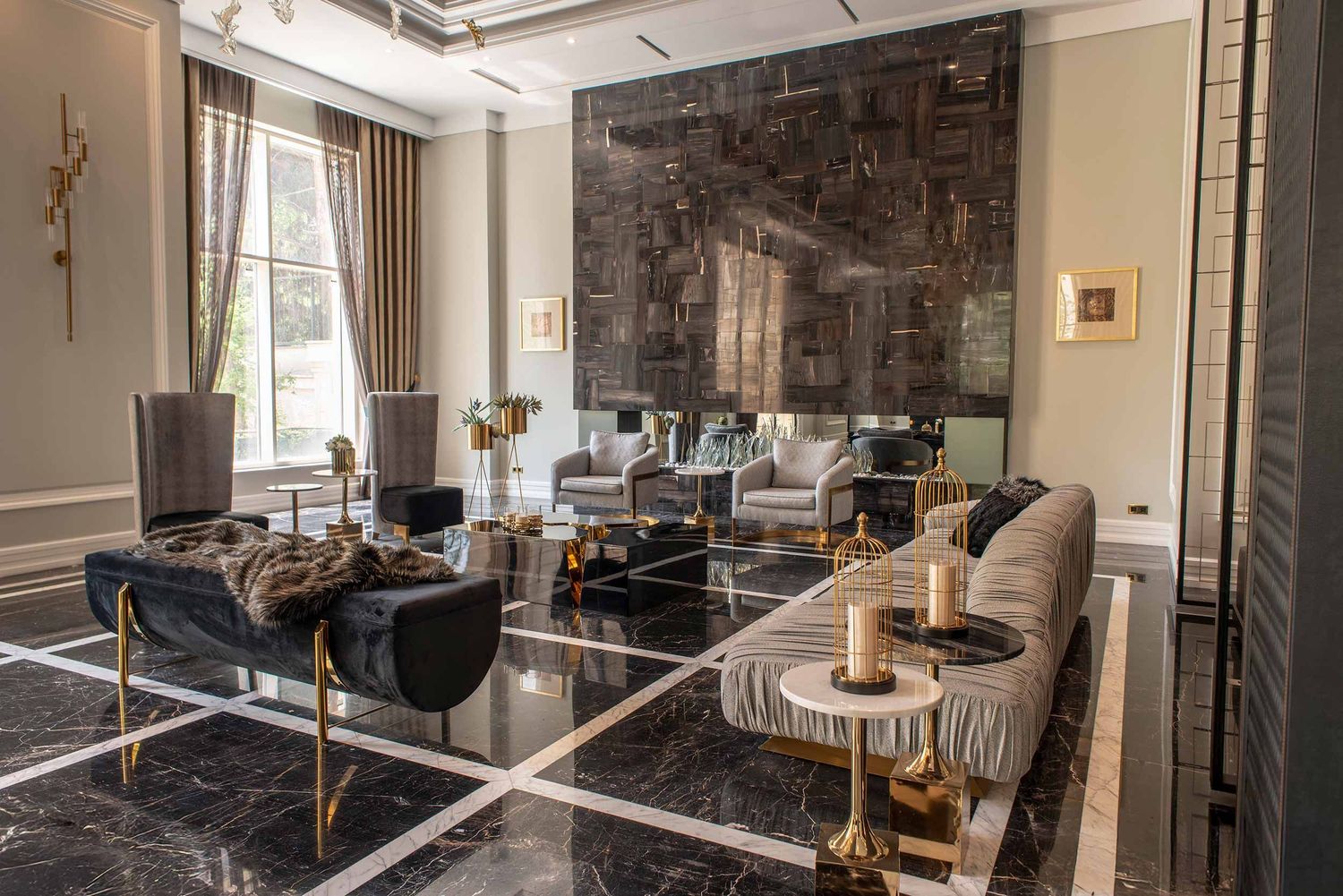 Contemporary living space featuring marble floors, designer seating, and dramatic wall art in dark tones.