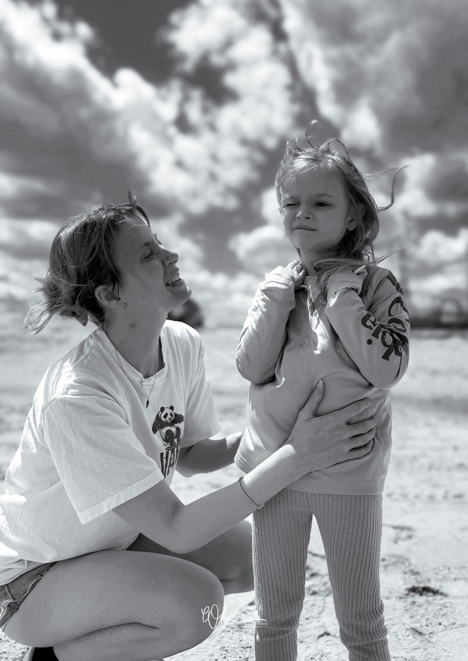 A series of black and white photographs showing tender moments between a parent and child playing on a sunny day outdoors.