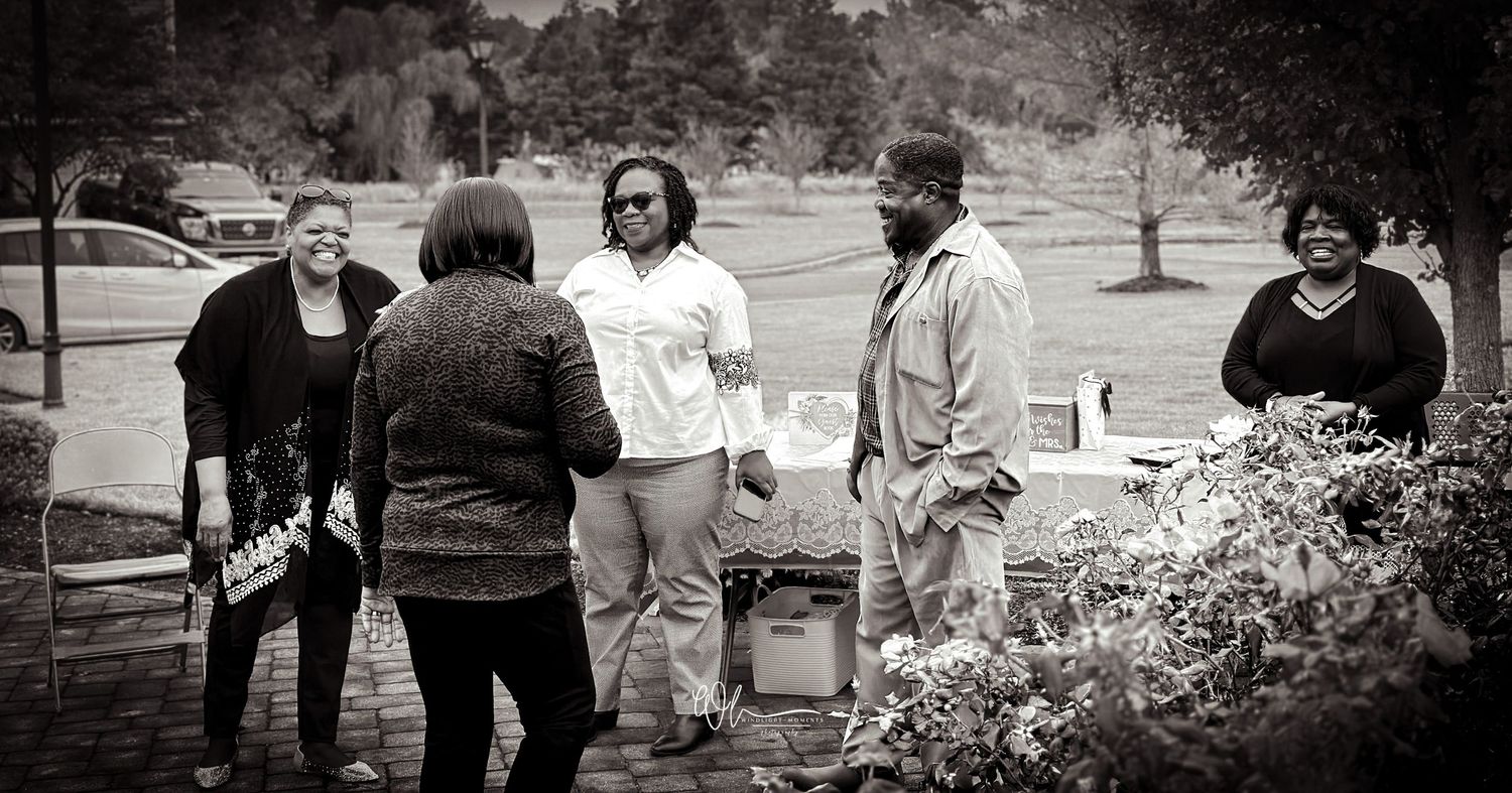 A group of people gather outdoors in a casual setting for a social event or gathering.