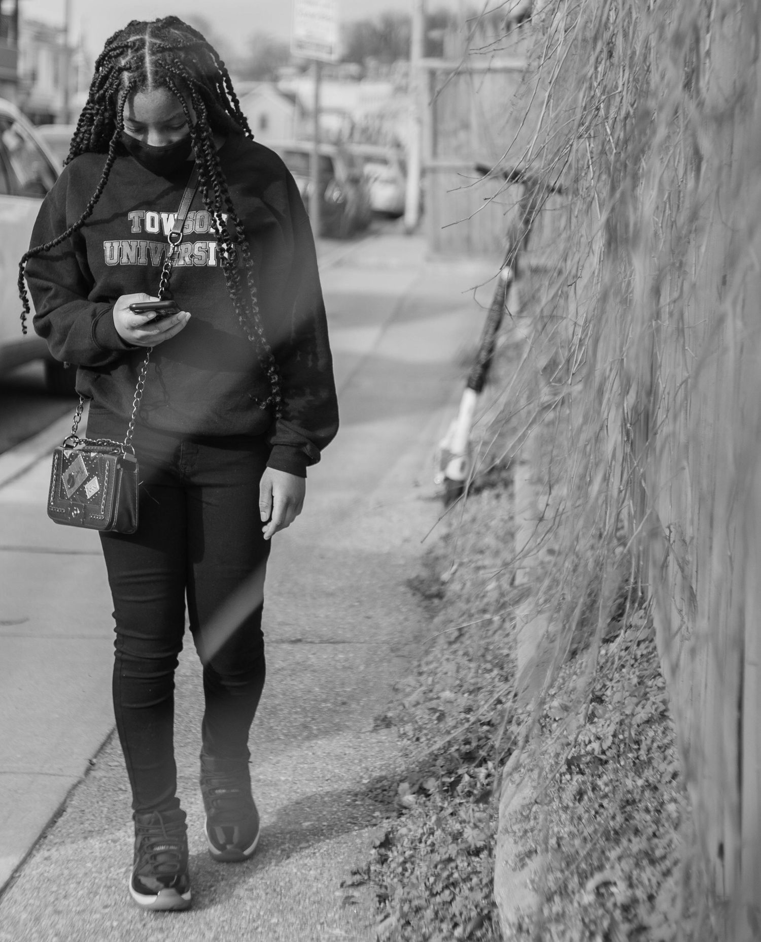 People walking along a concrete wall in black and white photography.