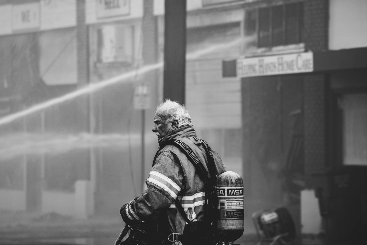Black and white urban street photography through a window or glass.