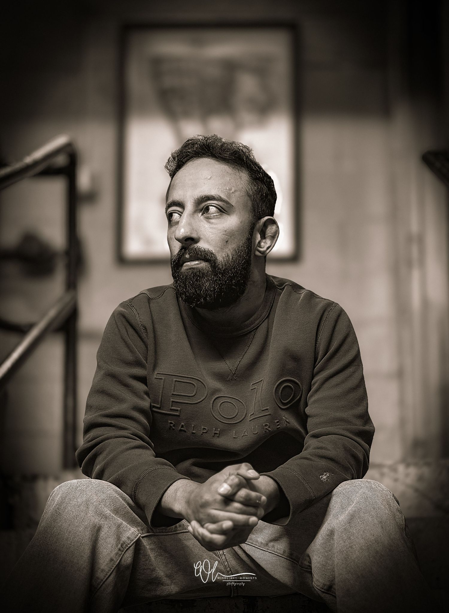 A black and white photo series showing a bearded man in casual attire sitting and looking contemplative.