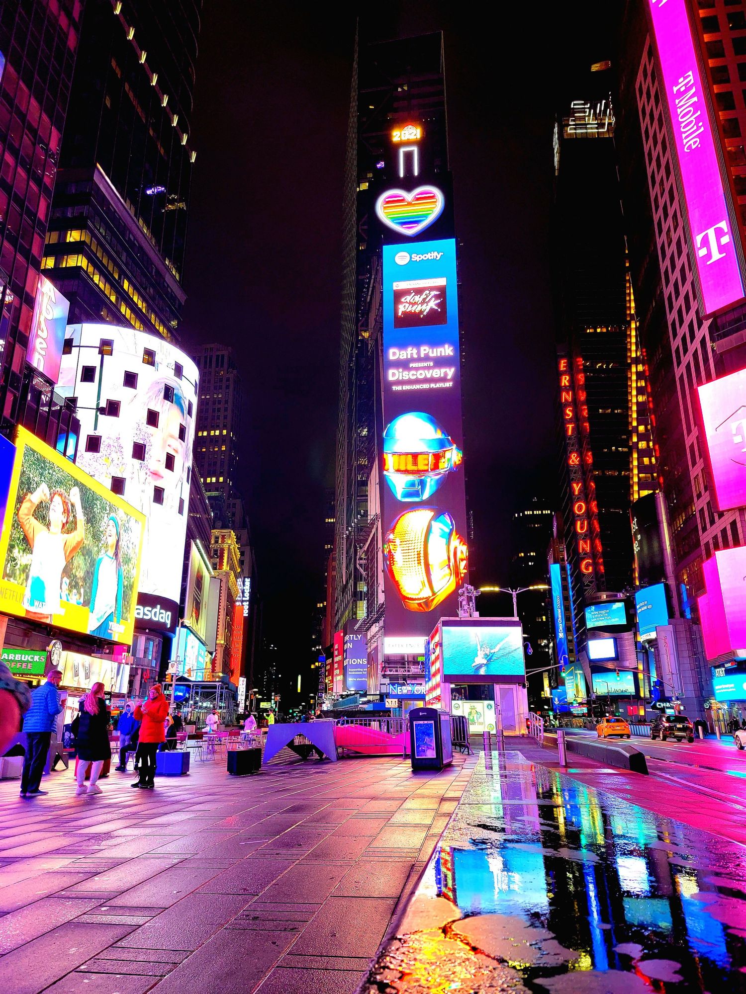 Vibrant nighttime view of Times Square with colorful neon signs and digital billboards illuminating the street.
