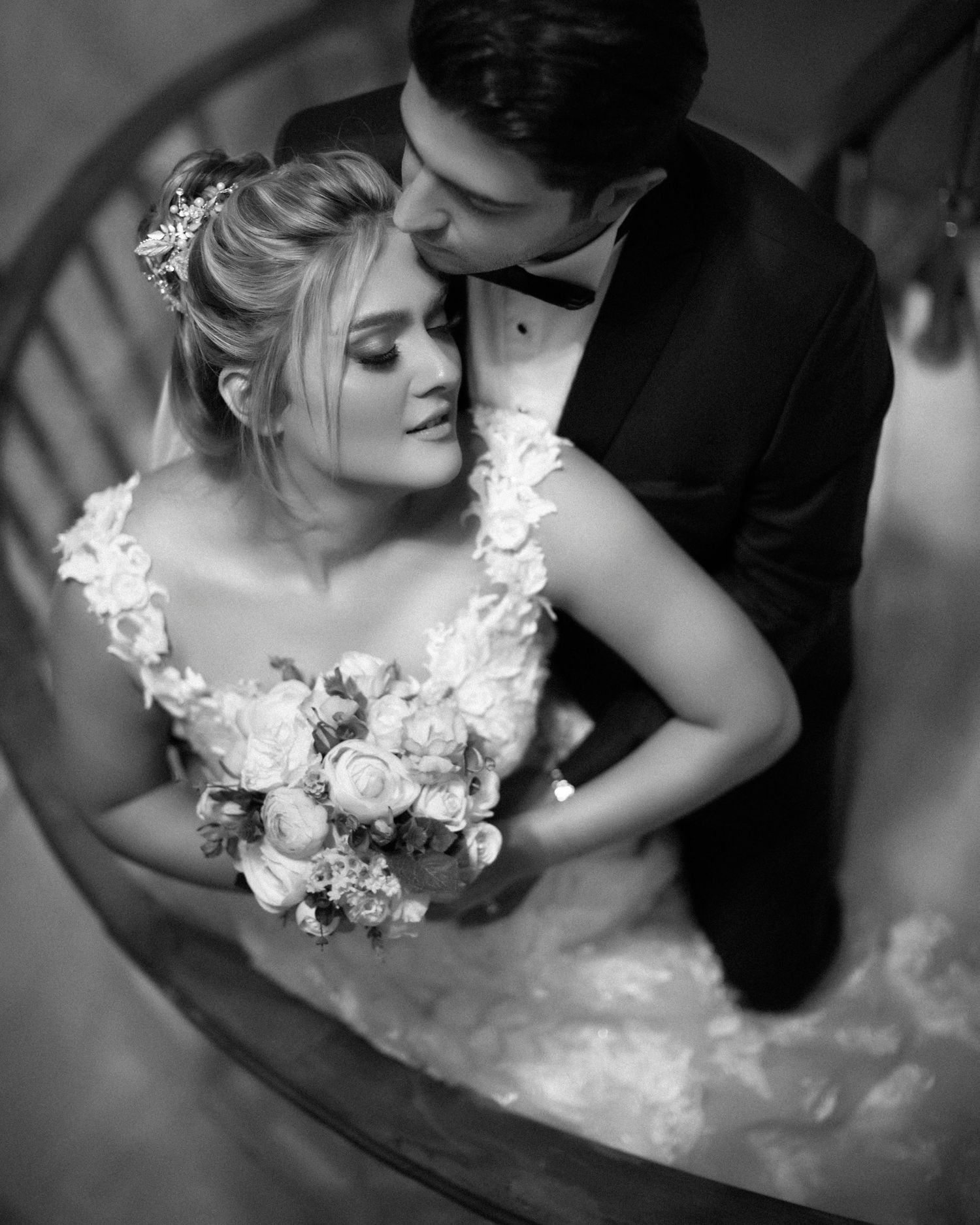 Artistic black and white wedding photo with bride holding bouquet.