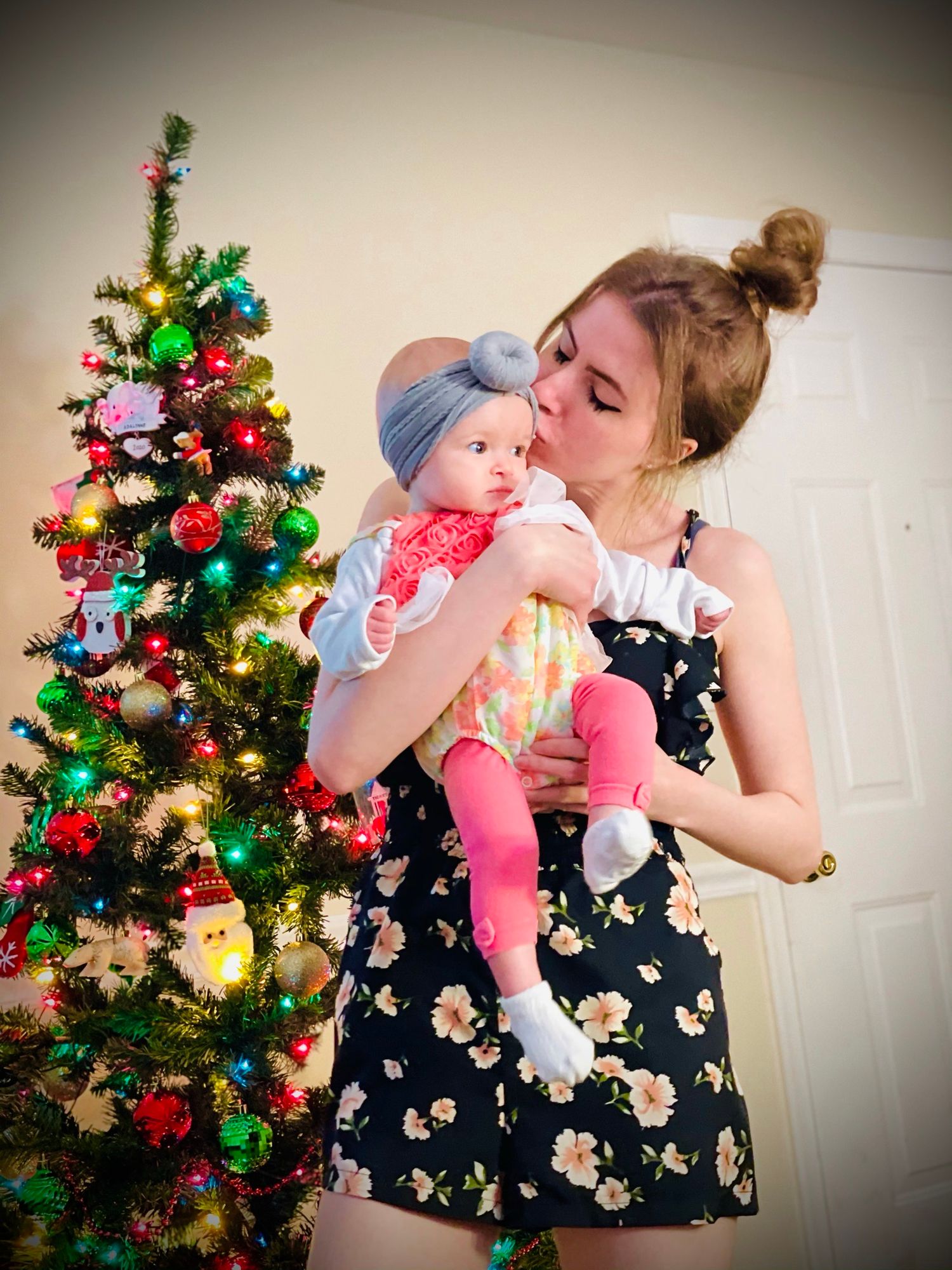 Festive Christmas scene with decorated tree and holiday lights in a cozy home setting.