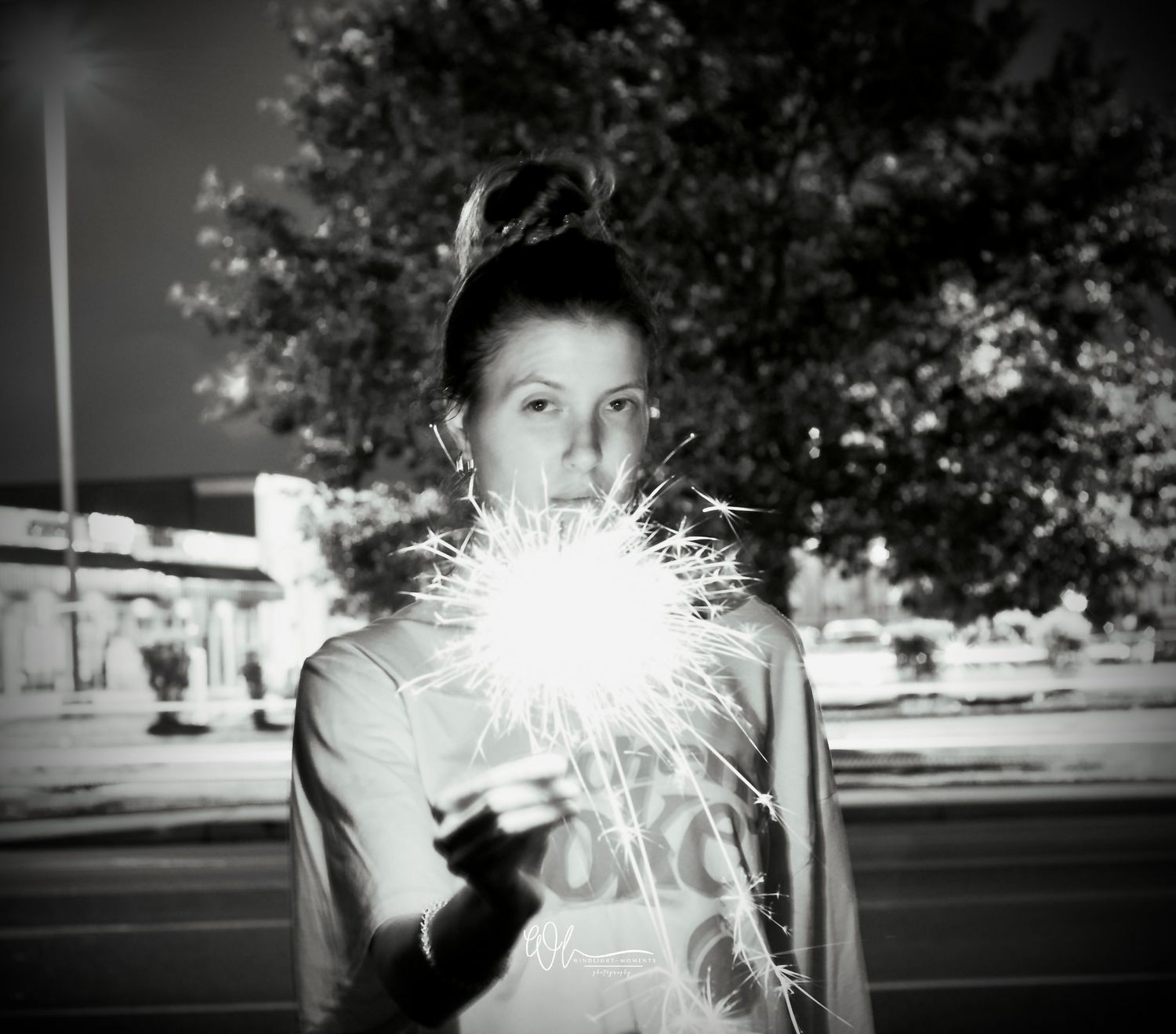 A sequence of black and white photographs showing sparklers creating light trails in the dark.