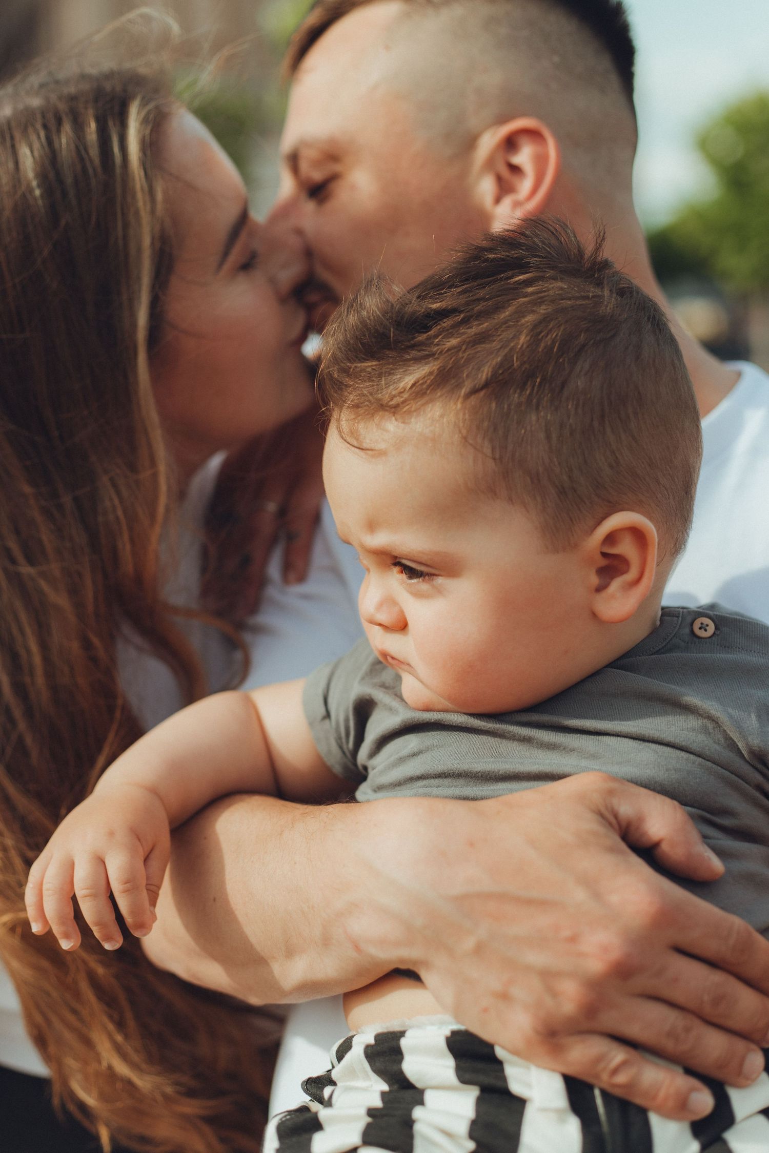 A tender family embrace captured in warm sunset lighting.