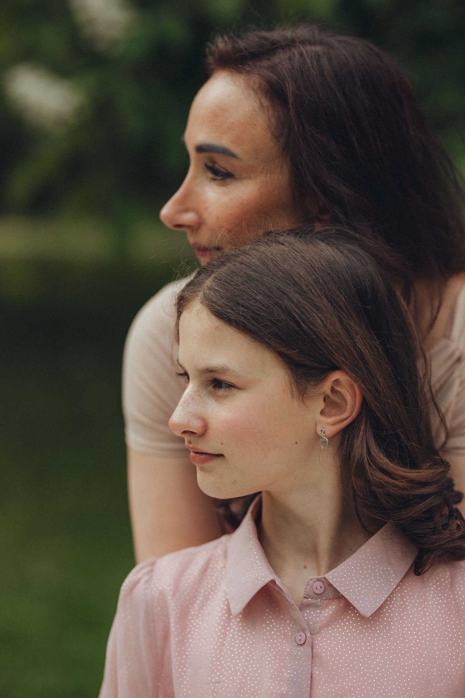 Side profile portrait of two women with similar features in soft natural light.