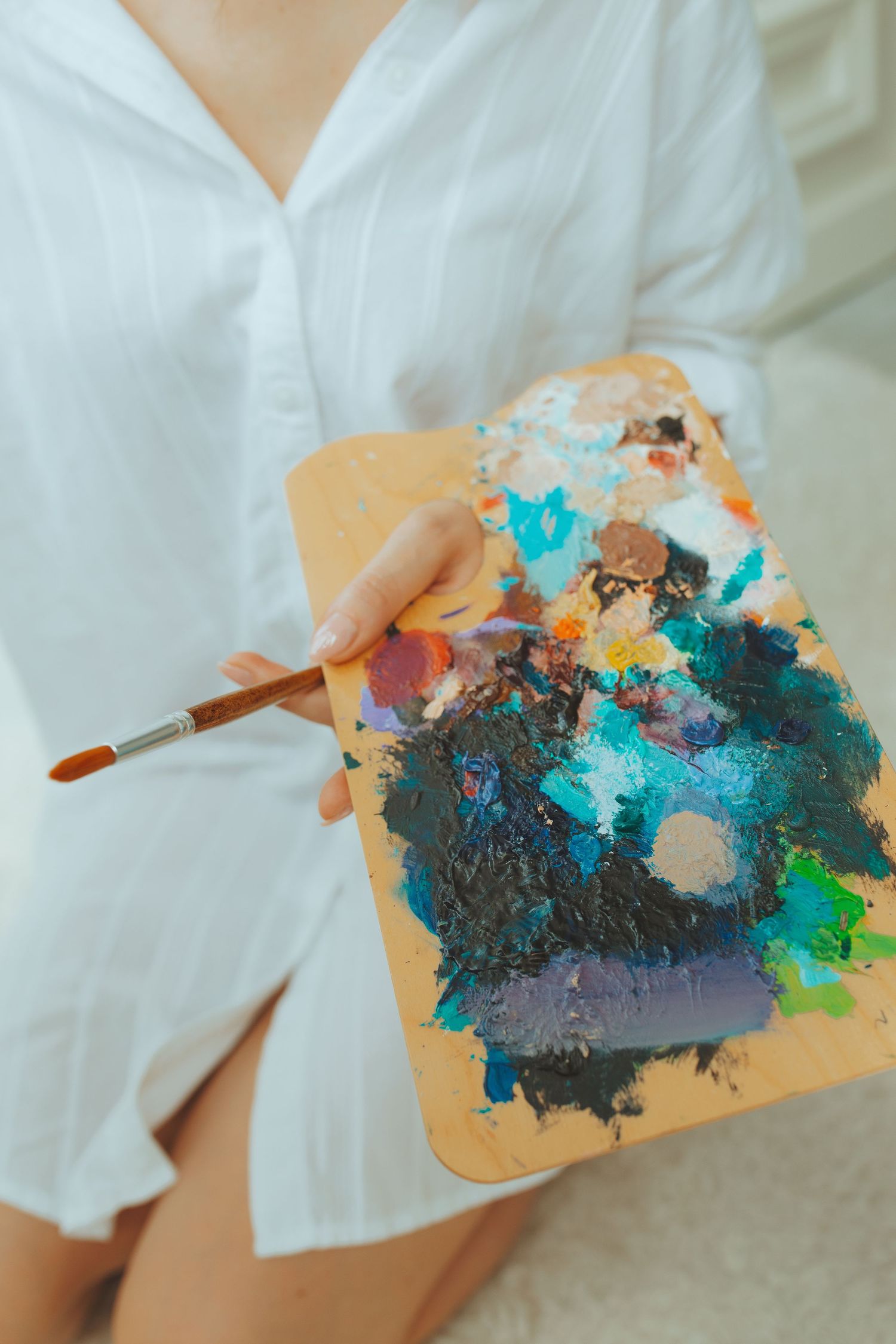 Paint palette with vibrant blue and turquoise colors mixed with darker tones.