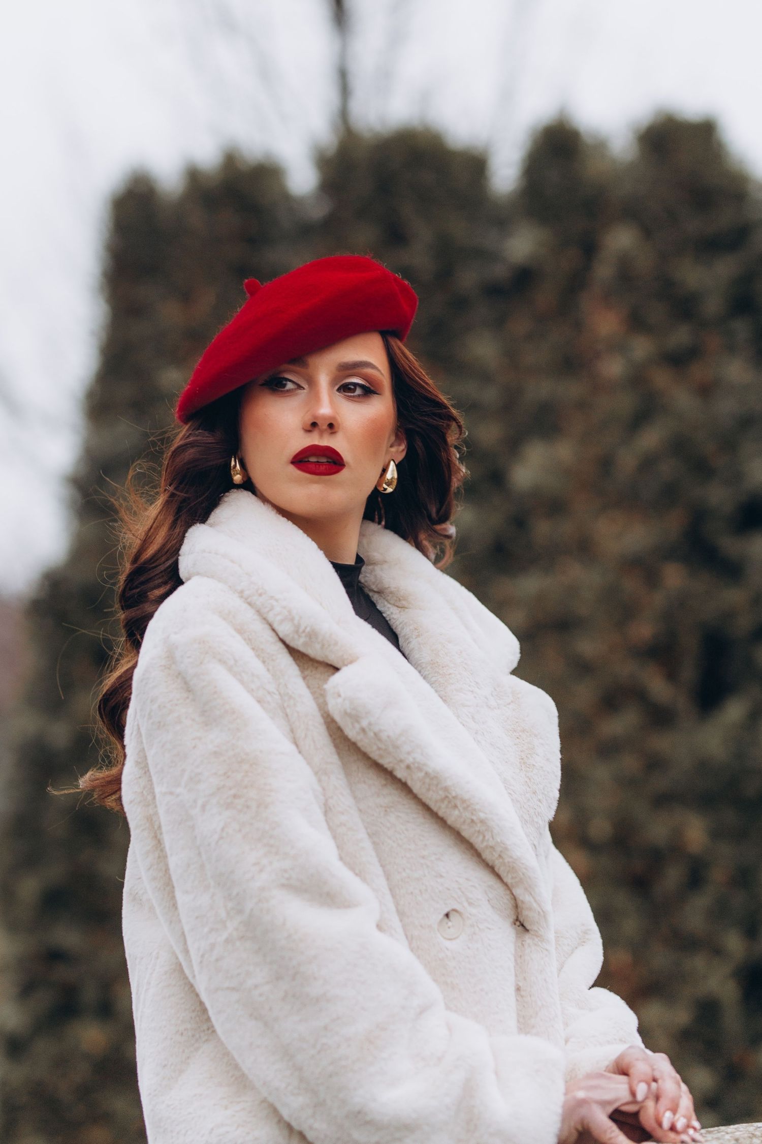 Winter fashion portrait with red beret and white faux fur coat.