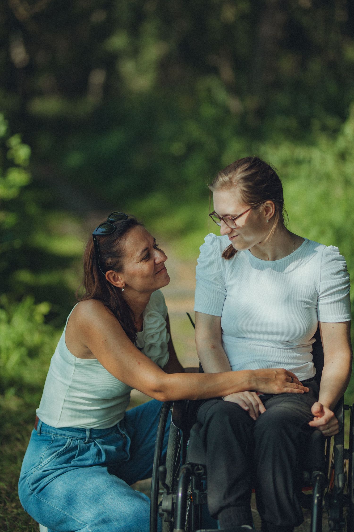 Tender moment between two people in a sunlit garden setting.