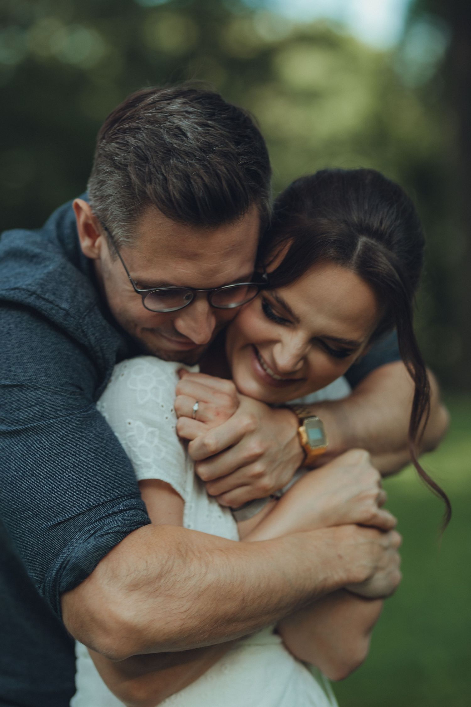 A tender embrace captured outdoors with soft natural lighting and genuine emotions.