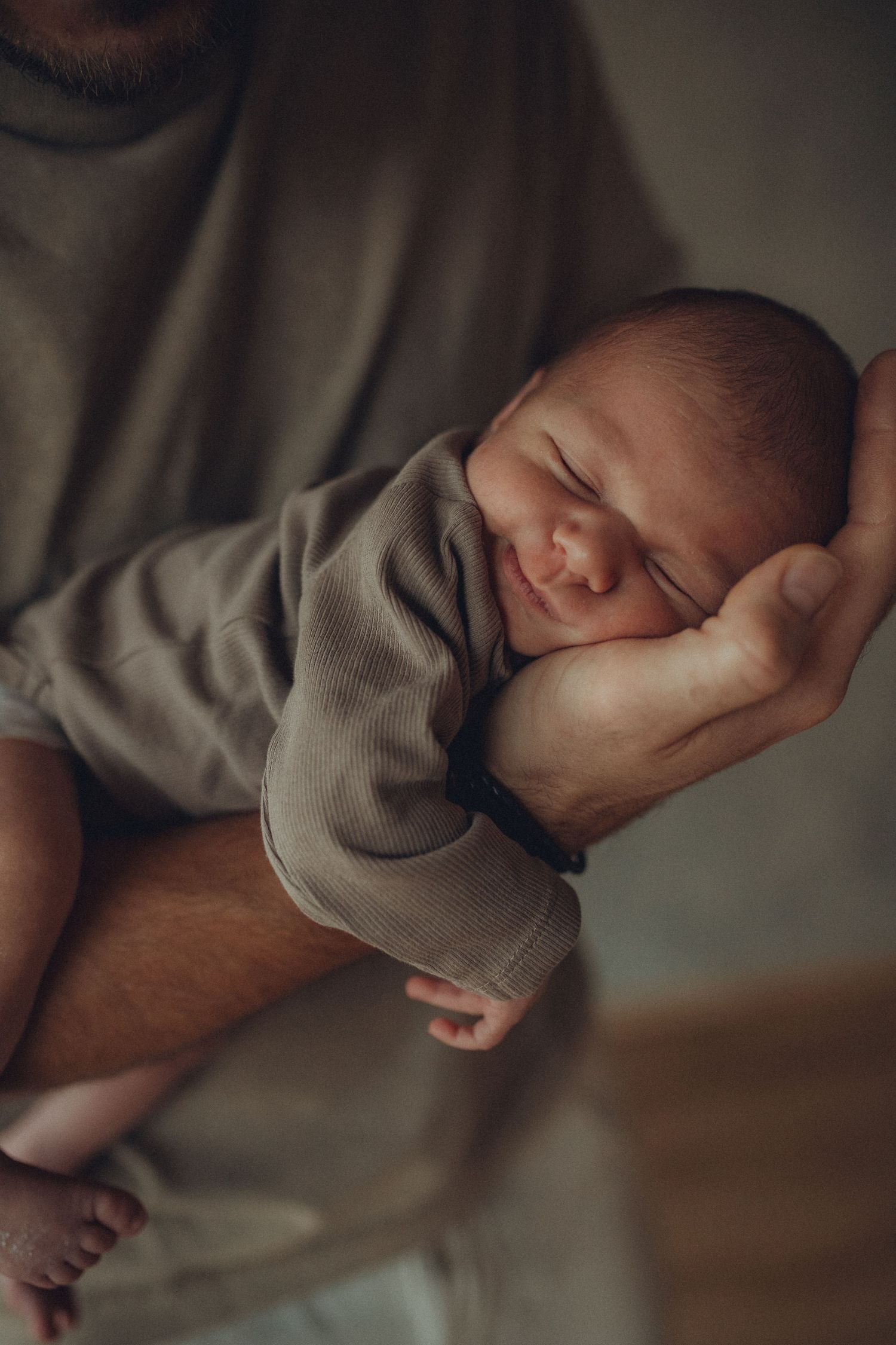 A sleeping baby wearing a gray sweater is captured in multiple peaceful poses.