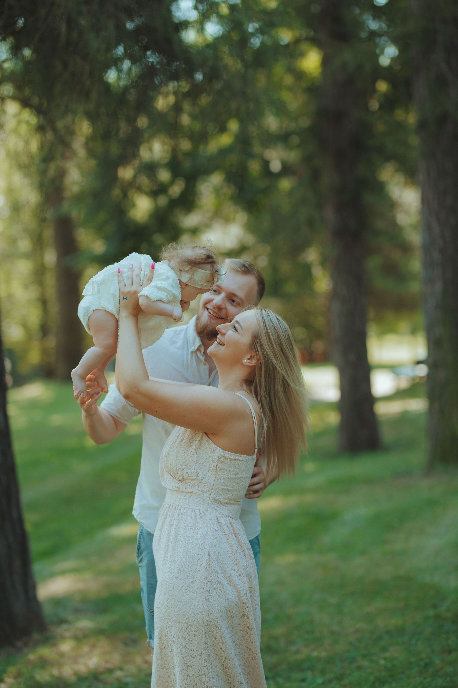 Joyful family moment captured in sunlit park setting.