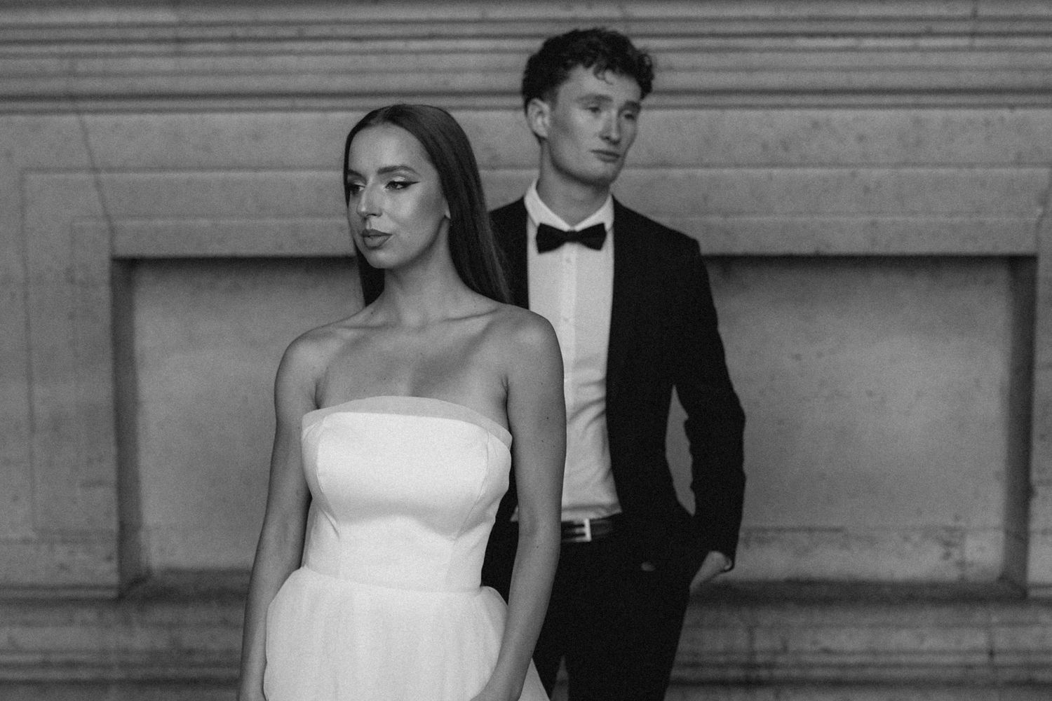 Black and white wedding photos showing romantic moments against stone architecture.