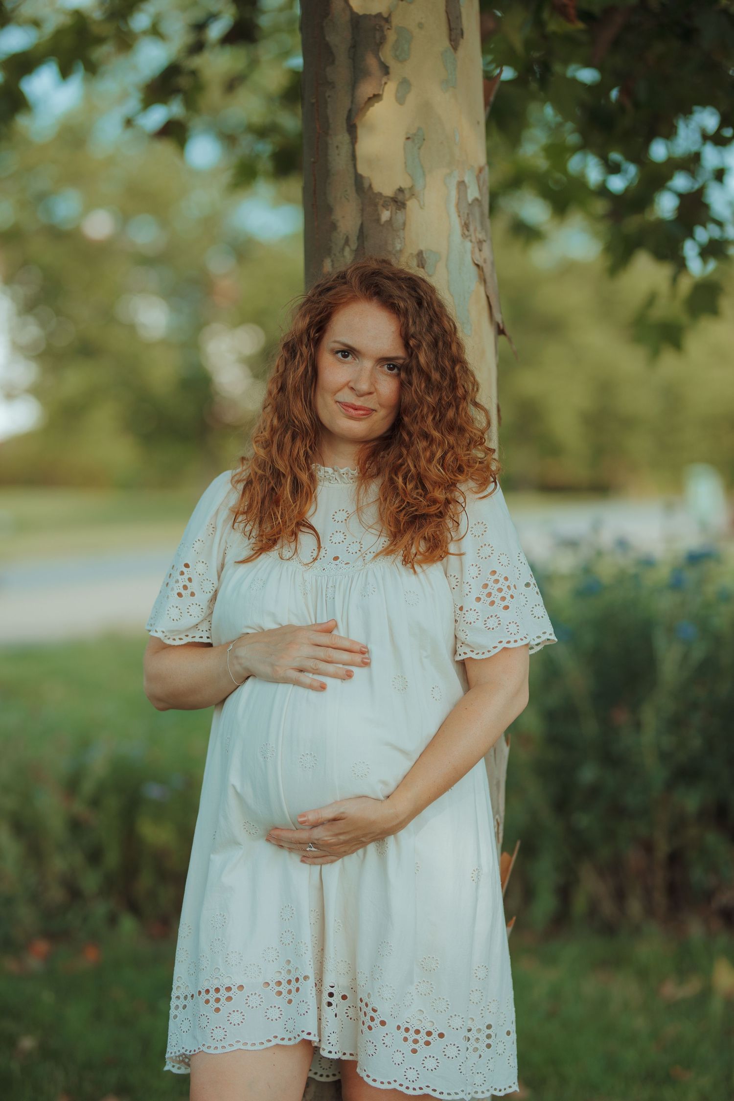 A flowing white eyelet lace dress shown in multiple poses against a natural outdoor background.