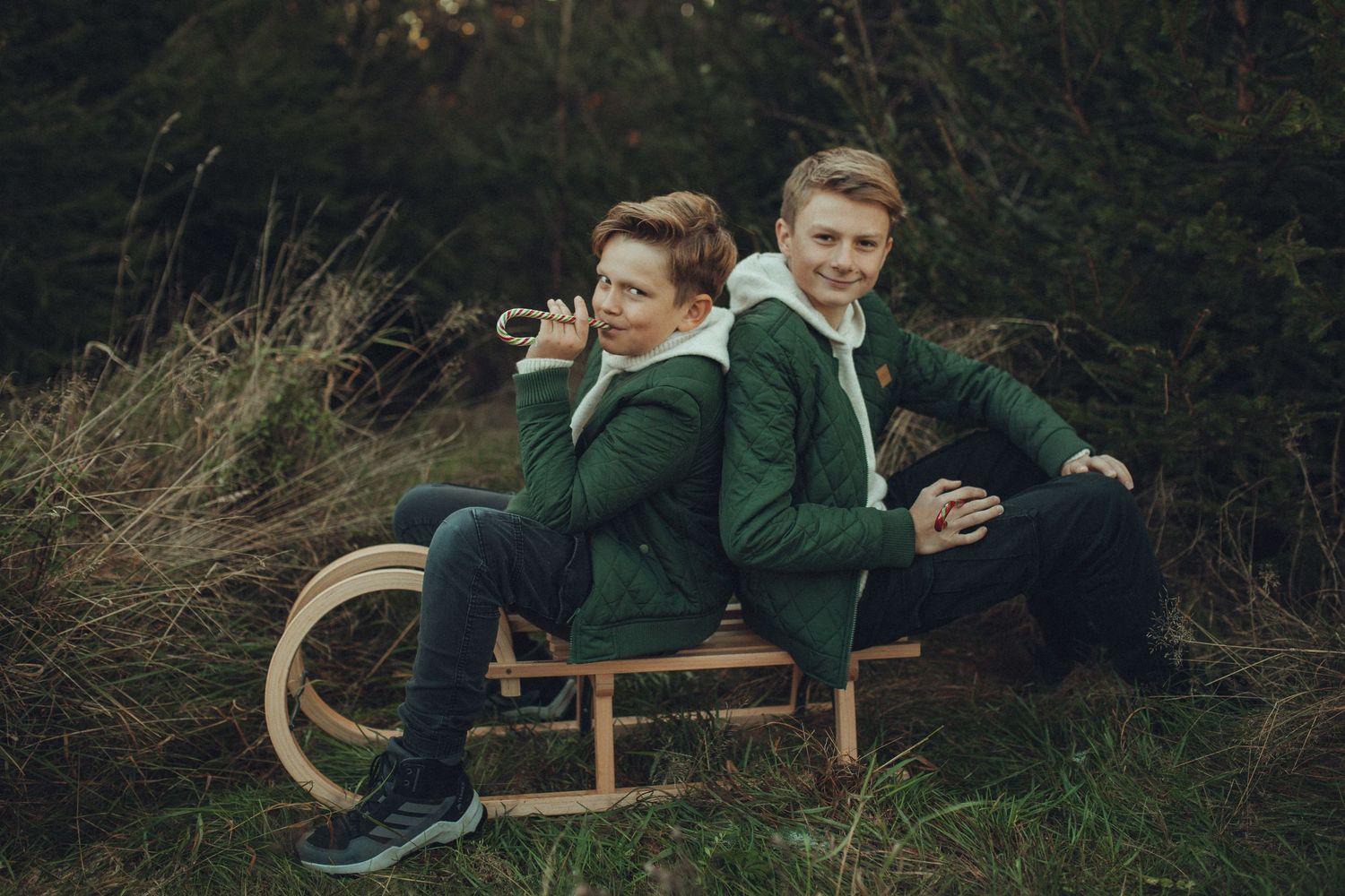 A series of candid outdoor photos showing playful interactions between two people in green jackets on a wooden bench.