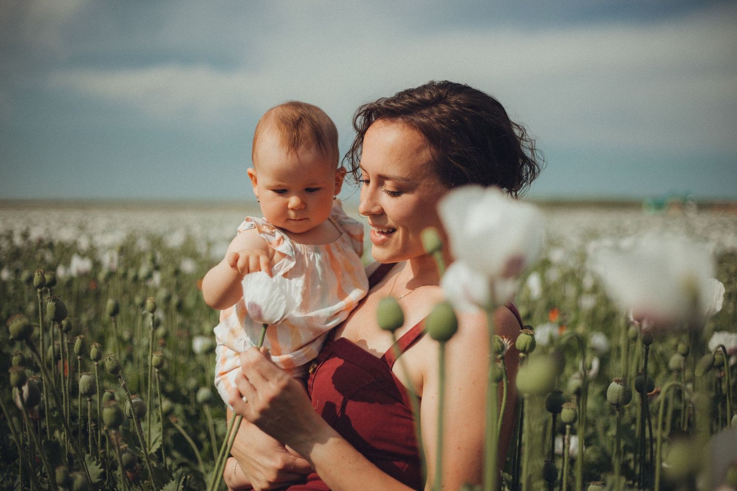 A tender moment between parent and child in a sunny wildflower field.
