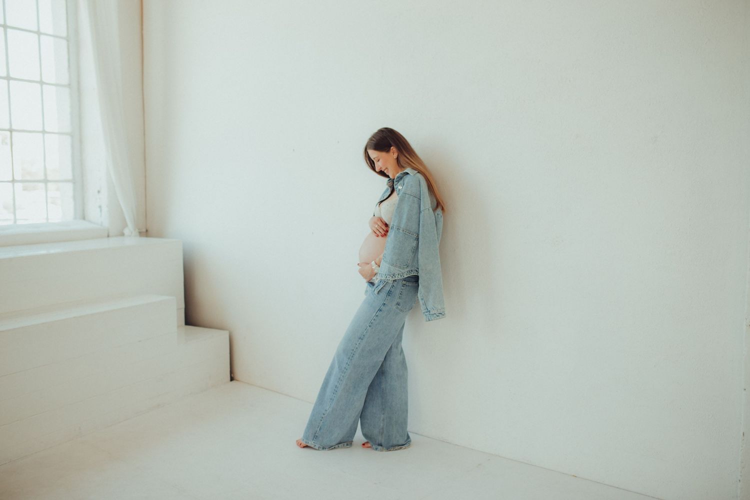 A series of minimalist photos showing a figure in blue denim against white walls in different contemplative poses.