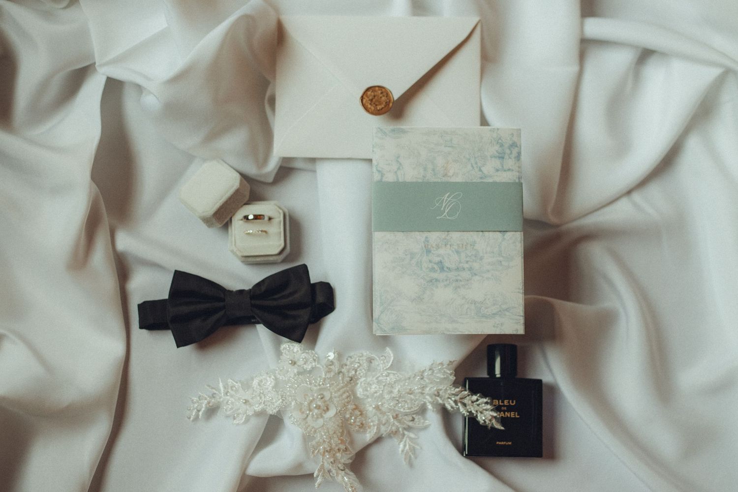 Wedding accessories including bow tie and delicate lace details on white fabric.