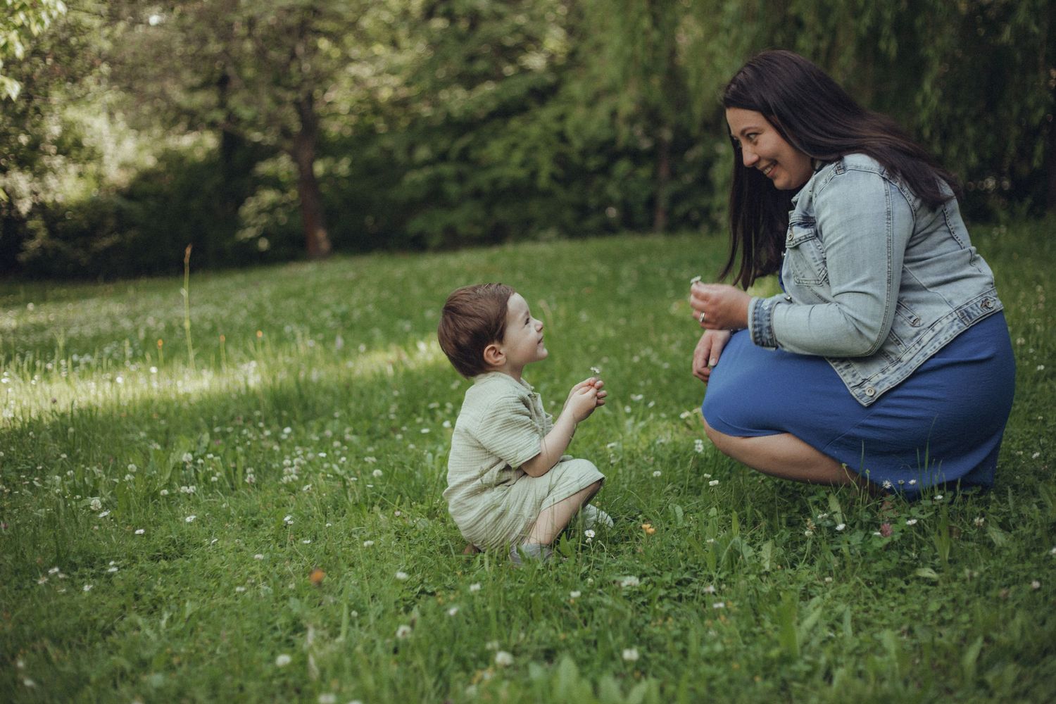 A playful interaction between two people on grass in springtime.