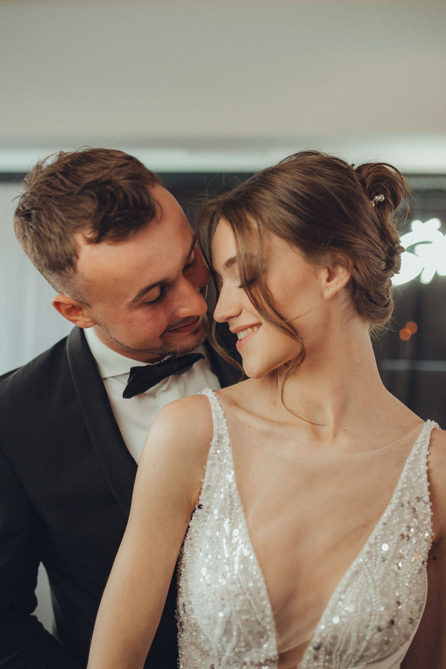 Intimate romantic moment captured in a sparkling wedding dress and formal attire.