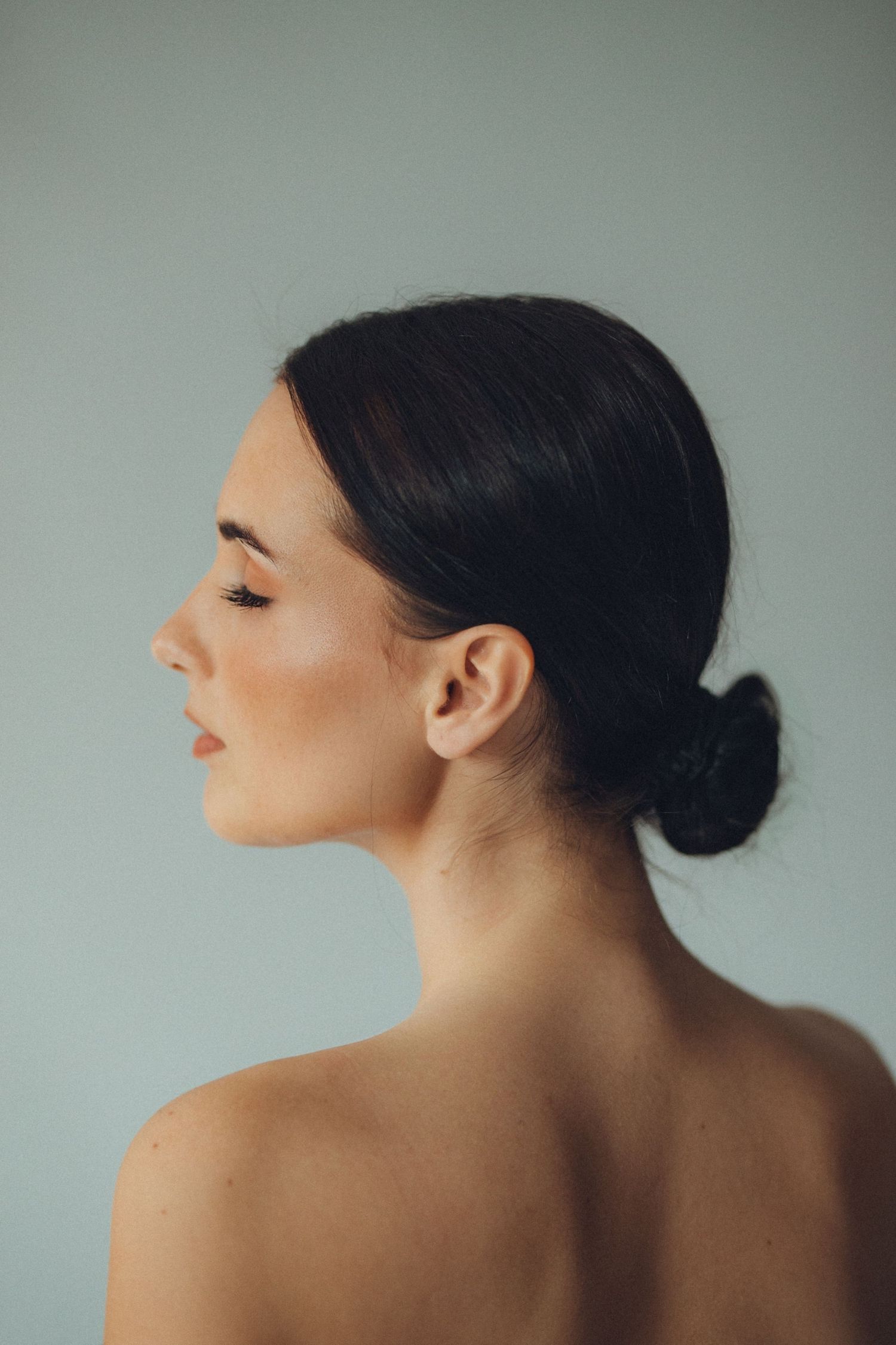 Artistic profile portrait showcasing sleek hair and natural makeup.