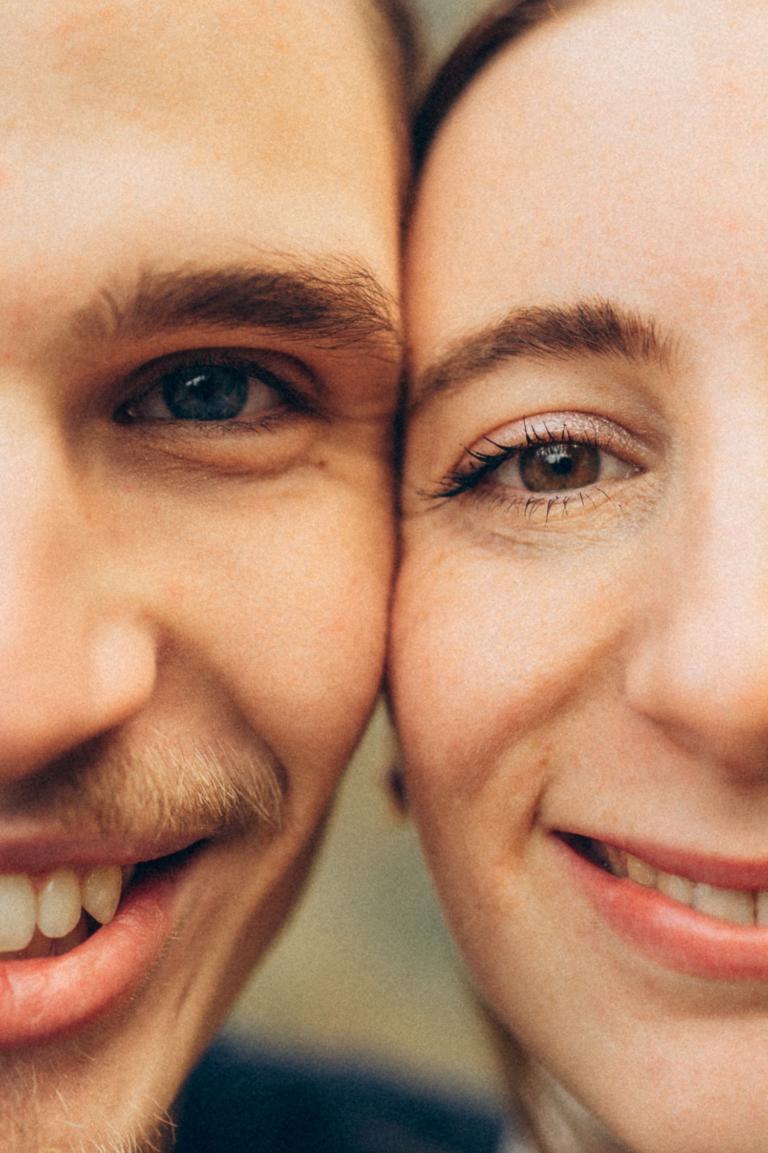 Close-up photo of a couple's faces sharing a happy, intimate moment together.