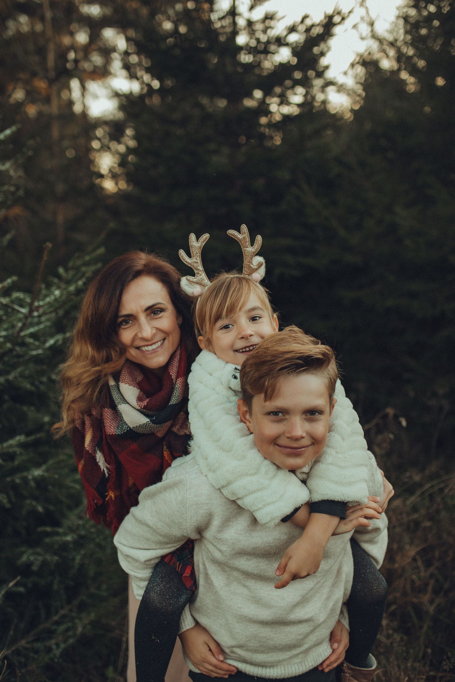 A heartwarming family moment captured in a forest setting with warm autumn lighting.