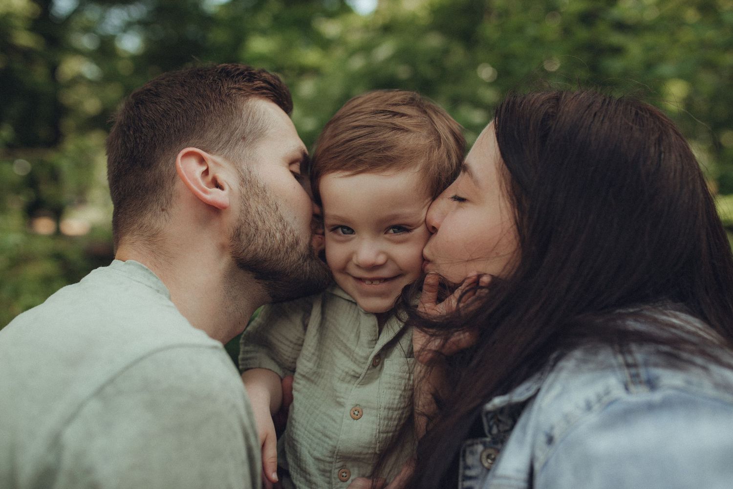 A sweet family moment shared between three in a green park setting.
