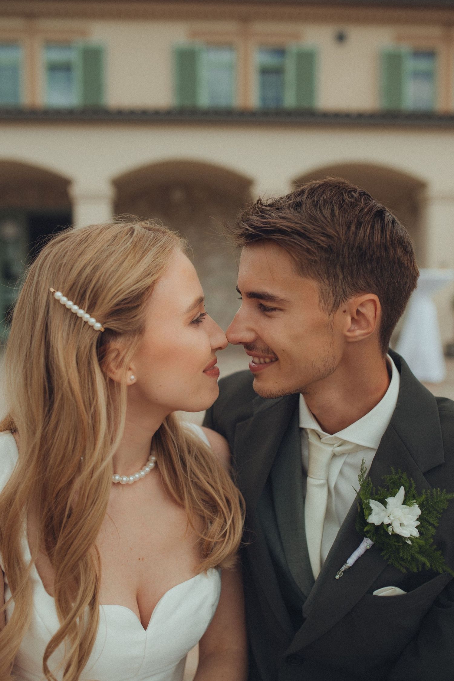 Intimate wedding portrait showing tender moment between bride and groom outdoors.